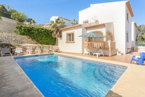 a swimming pool in front of a villa at Monte Verde in Jávea