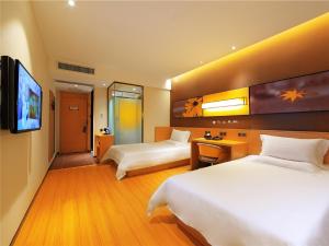 a hotel room with two beds and a flat screen tv at IU Hotel Norh Guiyang Century City Convention Center in Guiyang