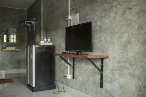a television sitting on a table next to a refrigerator at Navy Sisatchanalai in Ban Nong Chang