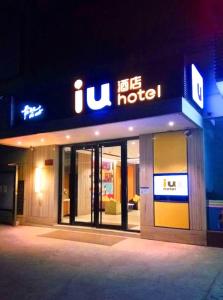 IU Hotel Wujiang Huadong Business City Tongli في سوتشو: متجر أمام الفندق في الليل