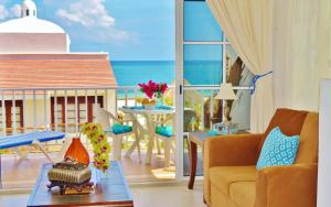 a living room with a view of the ocean at Corales Suites in Puerto Morelos