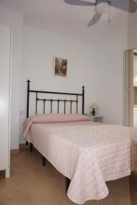 1 dormitorio con 1 cama con colcha rosa en Castillo de Santa Clara, en Torremolinos