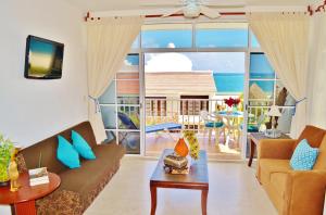 a living room with a view of the ocean at Corales Suites in Puerto Morelos