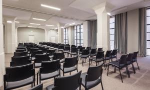 a room with rows of chairs in a room with windows at Vincci Porto in Porto