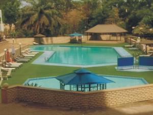 a large swimming pool with chairs and umbrellas at Nicon Luxury Abuja in Abuja