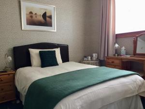 1 dormitorio con 1 cama con manta verde en Abermar Guest House en Inverness