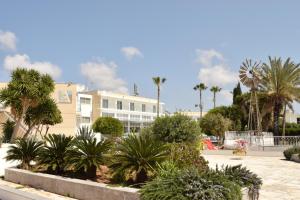 a park with palm trees and a white building at Fedrania Gardens Hotel in Ayia Napa