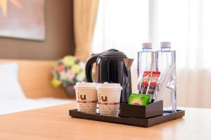 una cafetera y tazas de café en una mesa en IU Hotel Shijiazhuang Airport, en Zhengding