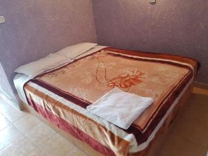 a bed sitting against a wall in a room at Residence Tafat in Agadir