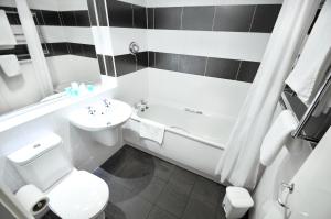 a bathroom with a toilet and a sink and a bath tub at Alma Lodge Hotel in Stockport