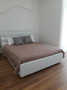 a bed in a bedroom with a white wall at Il sogno di Ele in Polignano a Mare