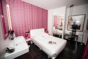 1 dormitorio con cama blanca y pared de ladrillo rojo en Posada del León de Oro Boutique Hotel, en Madrid