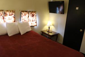 1 dormitorio con 1 cama con almohadas blancas y lámpara en Red Caboose Motel & Restaurant en Ronks