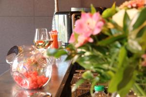una mesa con dos copas de vino y un jarrón con flores en Villa Les Bains en Houlgate