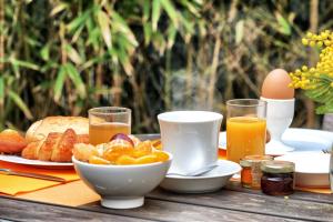 a table with a breakfast of bread and orange juice at Villa Les Bains in Houlgate