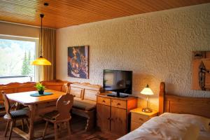 a bedroom with a bed and a table and a television at Bavarian Holiday Hideaway in Pfronten