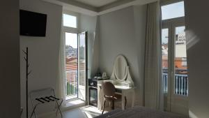 a bedroom with a bed and a desk and a mirror at Grande Pensao Residencial Alcobia in Lisbon