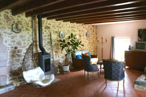 uma sala de estar com cadeiras e um fogão a lenha em La Fromagerie em Saint-Martin-le-Vieux
