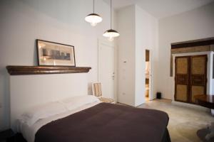 ein Schlafzimmer mit einem Bett und einem Bild an der Wand in der Unterkunft Belledonne Suite & Gallery in Neapel
