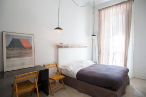 ナポリにあるBelledonne Suite & Galleryのベッドルーム1室(ベッド1台、デスク、椅子2脚付)