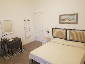 a bedroom with a bed and a table and a mirror at B&B Piazza Dante Nuoro in Nuoro
