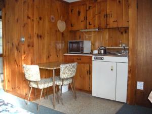 a kitchen with a table and two chairs and a microwave at Bass River Motel in South Yarmouth