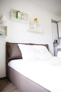 ミラノにあるAlessia's Flat - Sarpiの白い壁のベッド1台、棚が備わるベッドルーム1室