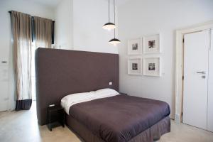 a bedroom with a bed with a brown headboard at Belledonne Suite & Gallery in Naples