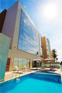 a large swimming pool in front of a large building at Marano Hotel in Salvador