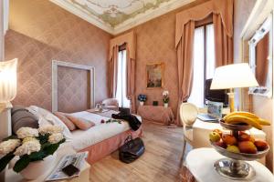 um quarto com uma cama e uma mesa com uma tigela de fruta em Duodo Palace em Veneza