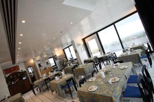 a dining room with tables and chairs and windows at Hotel Intervallo in Torre Lapillo