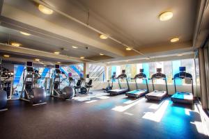 a gym with treadmills and ellipticals in a room at Pinnacle Hotel Harbourfront in Vancouver