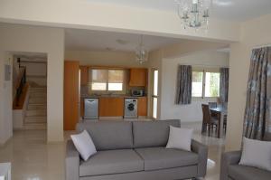 a living room with a couch and a kitchen at Anthorina Villa 8 in Protaras