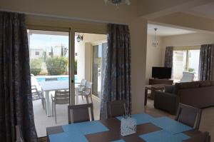 a living room with a couch and a table and a dining room at Anthorina Villa 8 in Protaras