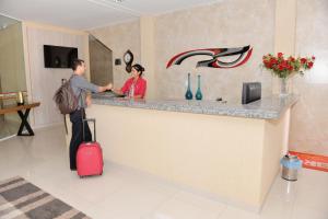 un hombre y una mujer parados en un mostrador en un hotel en Cajueiro Hotel, en Floriano