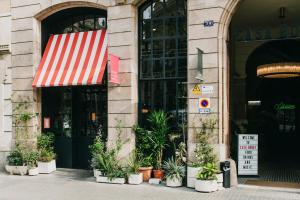 a building with a red and white awning and potted plants at Hotel Casa Bonay & Spa in Barcelona