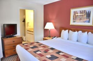 a hotel room with a bed and a television at Cresthill Suites Syracuse in East Syracuse +18 photos