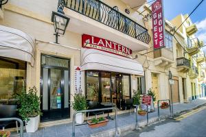 a building with a sign for a restaurant on a street at Lantern Guest House in Marsalforn