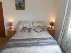 a bedroom with a bed with two pillows on it at Lletygwilym, Heol dwr in Kidwelly