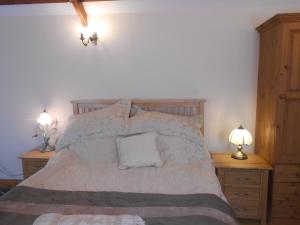 a bedroom with a bed with two night stands and two lamps at Lletygwilym, Heol dwr in Kidwelly