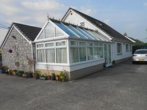 uma casa com muitas janelas num parque de estacionamento em Lletygwilym, Heol dwr em Kidwelly