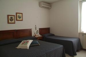1 Schlafzimmer mit 2 Betten und einem Fenster in der Unterkunft C.A.V. Residenza Prisco in Marina di Grosseto