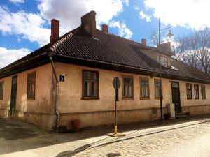 un viejo edificio con una señal de stop delante de él en Kalna ielas Rezidence en Kuldīga