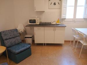 a kitchen with a chair and a table and a microwave at Hostal Juventus in Portbou
