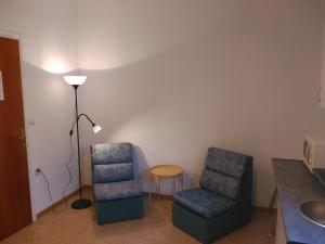 a room with two chairs and a table and a lamp at Hostal Juventus in Portbou