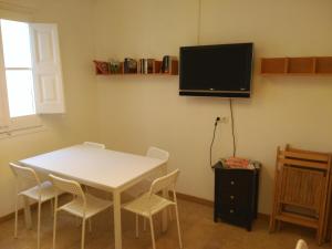 a room with a white table and chairs and a tv at Hostal Juventus in Portbou