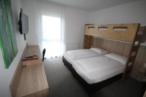 een slaapkamer met een stapelbed en een televisie bij Bernstein-Motel Marchegg in Marchegg +39 foto's