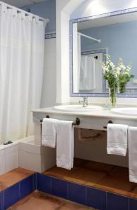 a bathroom with a sink and a mirror and a tub at Hotel Veracruz in Utrera