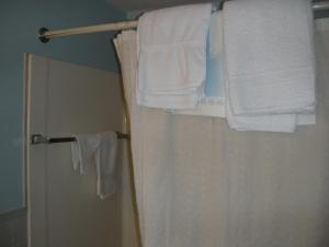 a bathroom with white towels hanging on a rack at Bass River Motel in South Yarmouth