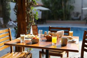 una mesa de madera con comida y vasos de zumo de naranja en Casa Andina Standard Nasca en Nazca